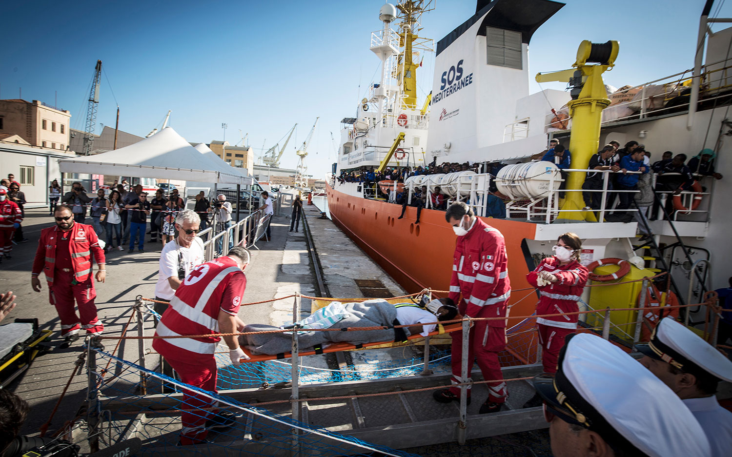 Menschen mit medizinischen Beschwerden, wie dieser Mann, der von Mitarbeitern des italienischen Rote Kreuzes in einer Trage getragen wird, waren die ersten, die die Aquarius in Palermo, Italien, verließen. 13. Oktober 2017