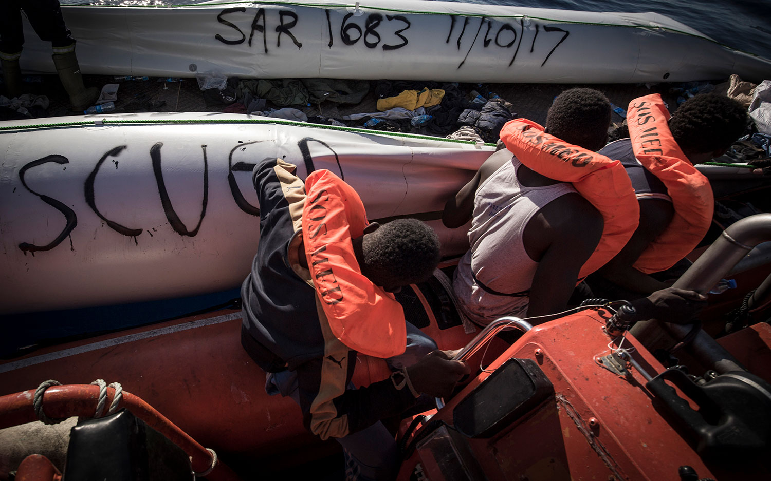 SOS MEDITERRANEE crew mark the rubber dinghy with the search-and-rescue (SAR) case number and date. October 11, 2017.