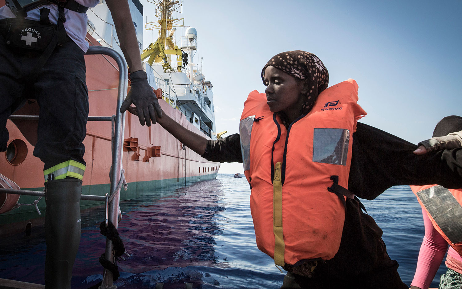 Rettungskräfte der SOS MEDITERRANEE helfen einer Somalierin von dem Festrumpfschlauchboot (RHIB), damit sie an Bord der Aquarius gelangen kann. 11. Oktober 2017.